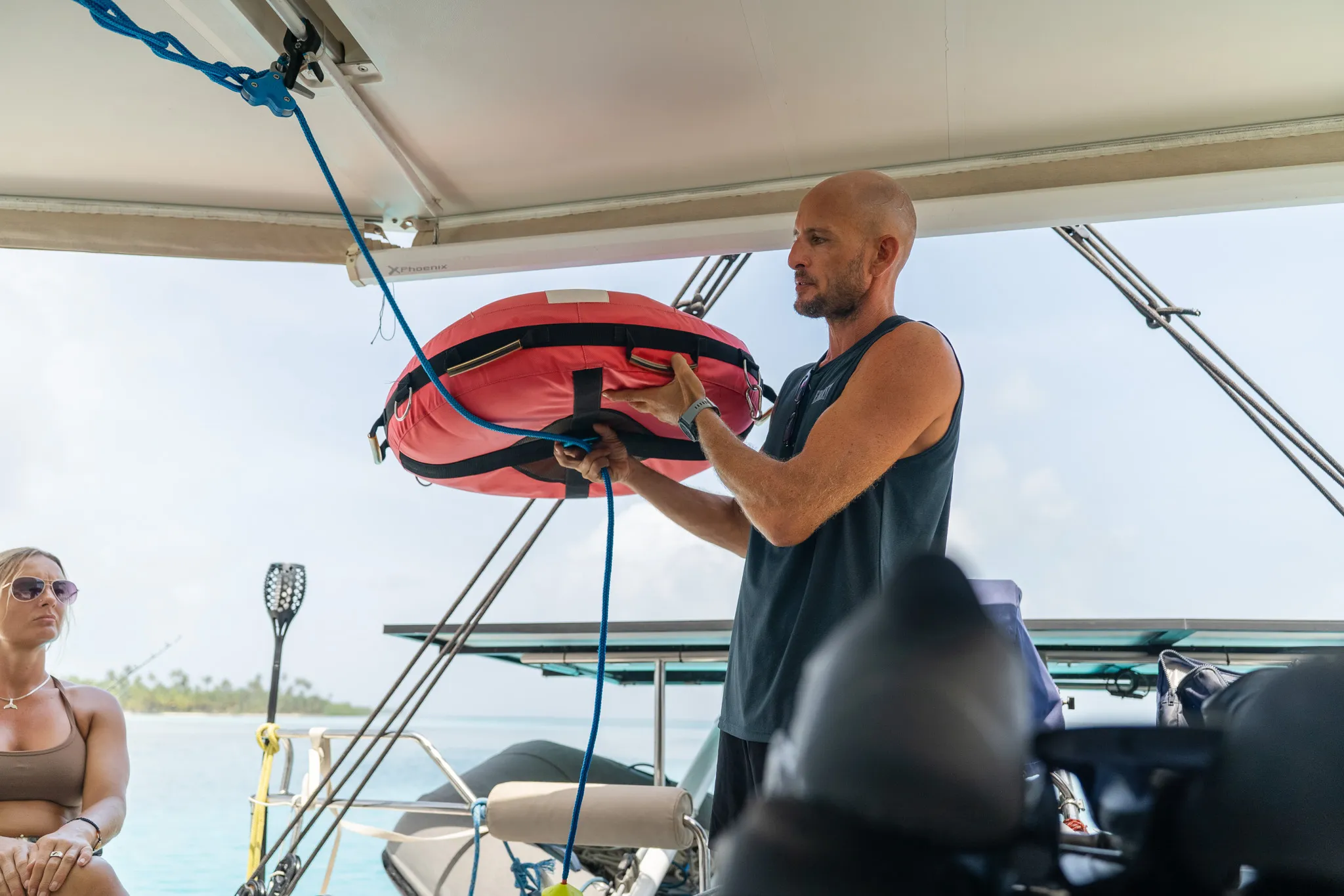 Un instructor sostiene la boya de apnea durante la charla en la bañera del catamarán.