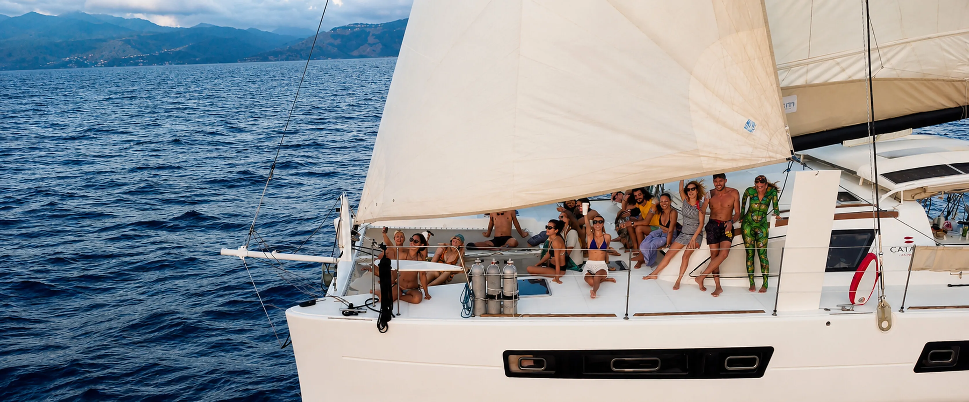 The crew aboard Ikigai, the Catana 47, sailing the coast at golden hour