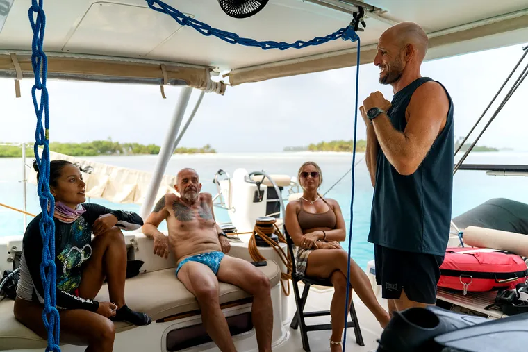 Freediving briefing in the catamaran cockpit, instructor and three participants.