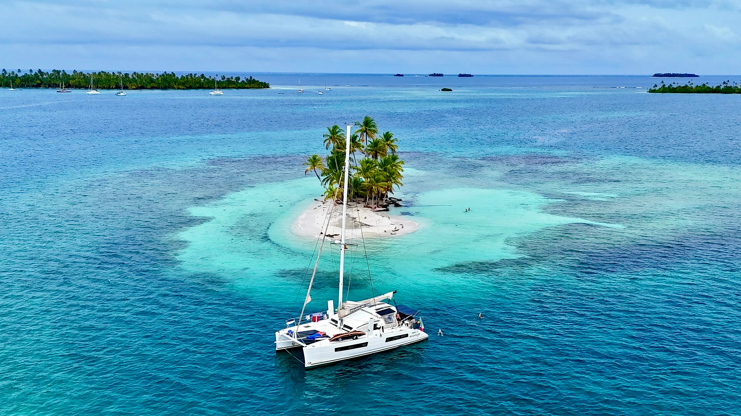 A palm-topped San Blas islet with Ikigai anchored in turquoise water